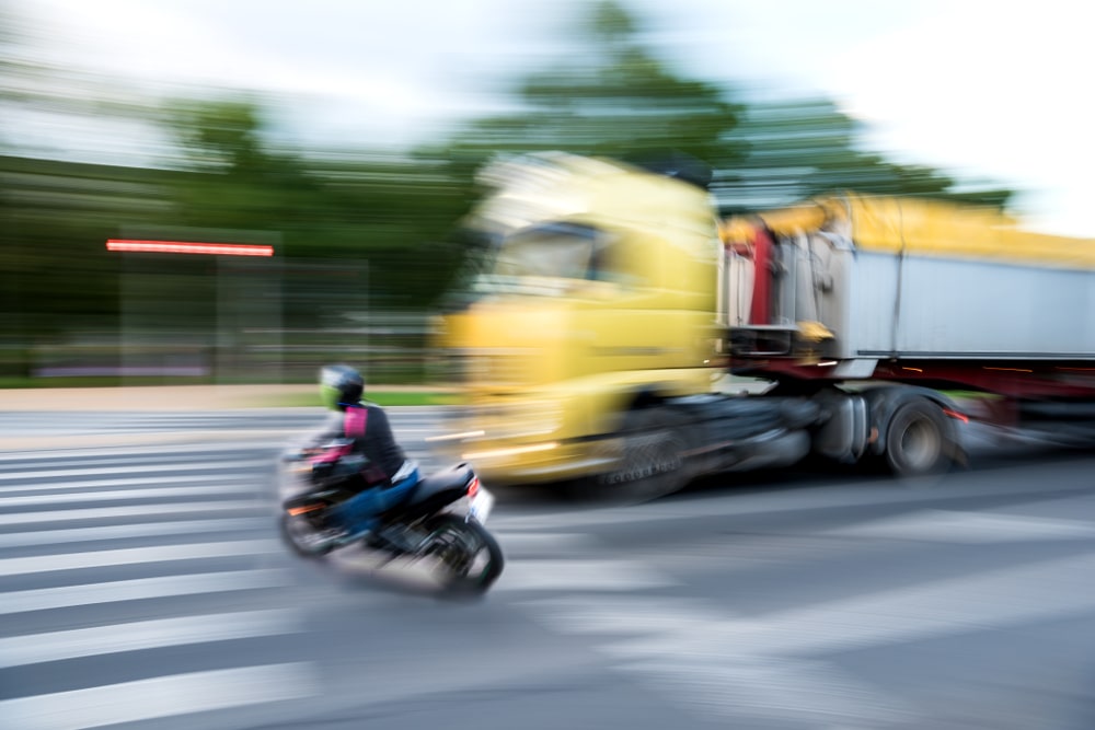 Motorcycle Driving In Front Of A Truck