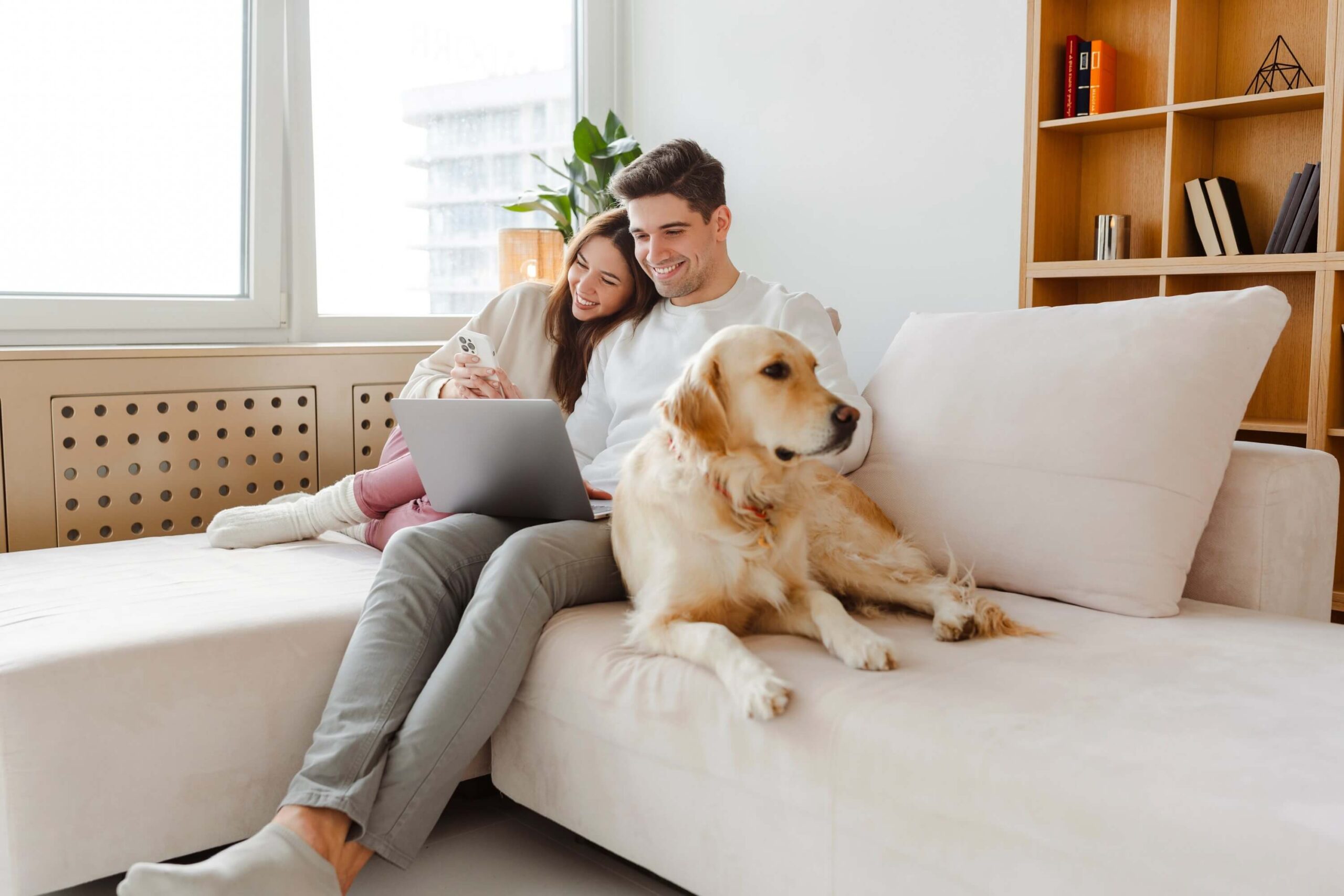 Portrait of happy young couple using laptop